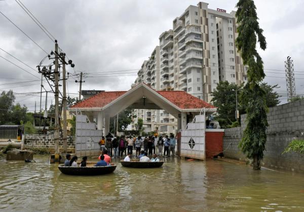 FILE PHOTO: People use Coracle boats to move through a water-logged neighbourhood following torrential rains in Bengaluru