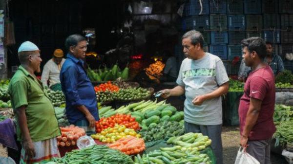 A customer bargains with a vegetable vendor at Kawran Bazar kitchen market of the capital on Friday. Photo: Rajib Dhar