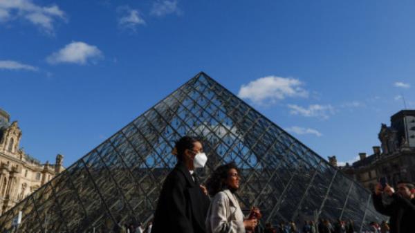 People wearing protective face masks walk near the glass Pyramid of the Louvre museum in Paris, amid the coro<em></em>navirus disease (COVID-19) outbreak in France, February 19, 2022. REUTERS/Go<em></em>nzalo Fuentes